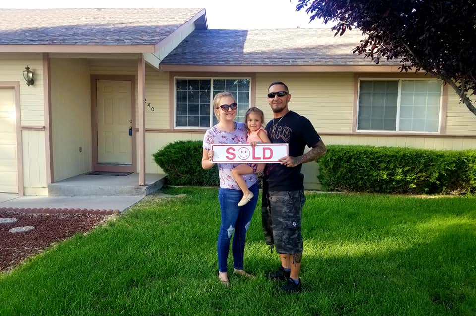 Family in front of their new home.